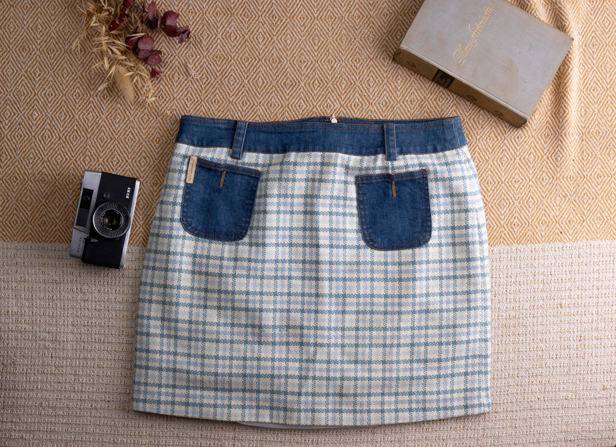Vintage D&G Dolce Gabbana Y2K Mixed Media Mini Skirt – pale blue and white houndstooth tweed body with contrasting indigo denim waistband, two denim patch pockets with gold D&G logo patch, back zip closure, straight mini silhouette, flat lay editorial shot