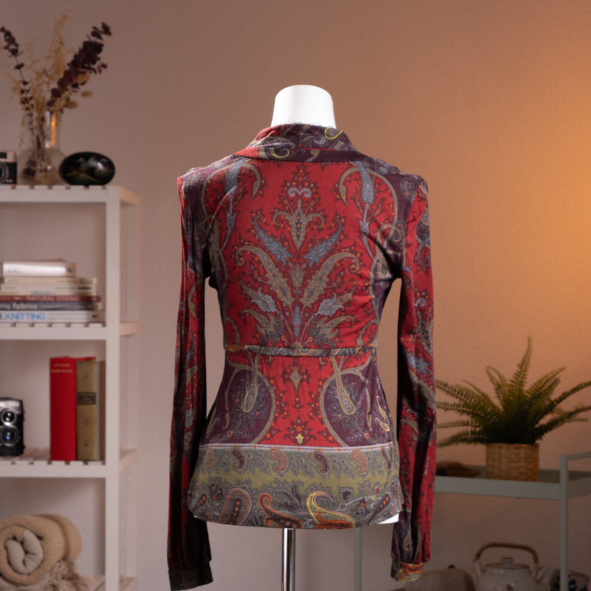 Archival Etro Milano 90s Paisley Wool Jersey Top – rich burgundy and purple wool jersey with all-over heritage paisley print in red, teal, gold and olive, deep V-neckline with draped crossover front, empire waist with gathered peplum hem, long sleeves, Made in Italy, product shot on dress form