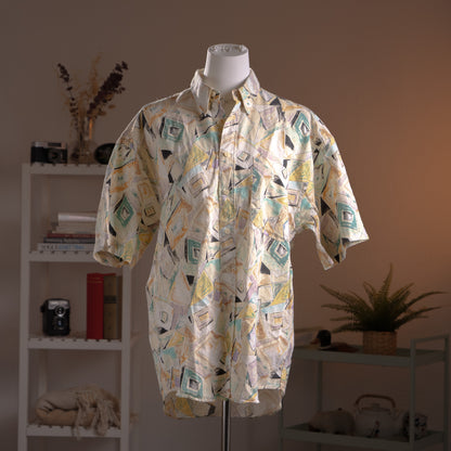 Archival Courrèges Paris 90s Modernist Abstract Print 100% Linen Shirt – cream linen with all-over geometric abstract print in teal, yellow, black and lavender, point collar, short sleeves, button-front, oversized unisex fit shown knotted at waist, avant-garde museum grade piece, product shot on dress form
