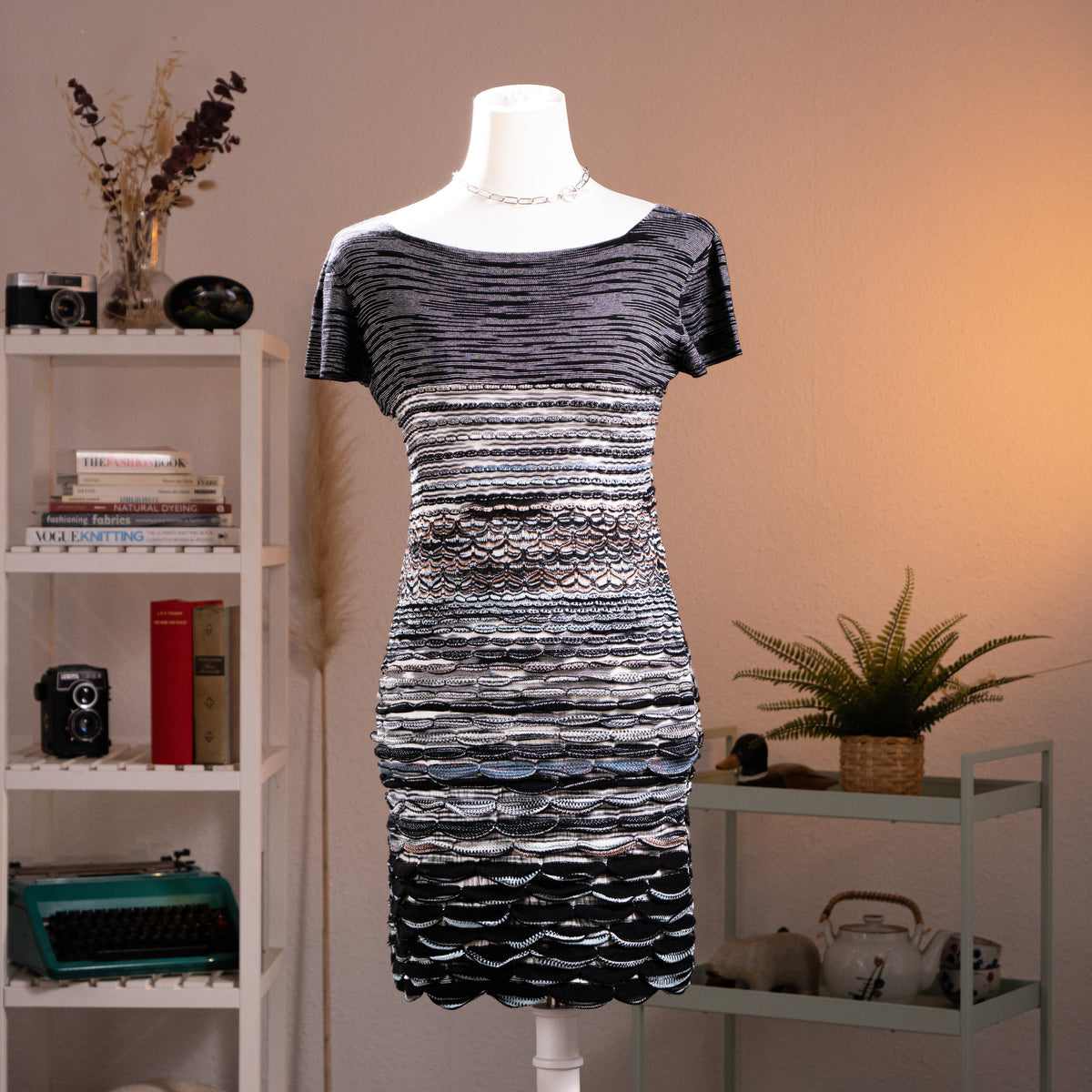 Archival Missoni Orange Label 90s 3D Scalloped Knit Mini Dress – black and silver metallic knit, wide scoop neckline, short sleeves, horizontal stripe bodice transitioning into dramatic 3D raised scallop shell texture panels at waist and skirt, body-con silhouette, textile sculpture Angela Missoni era, product shot on dress form