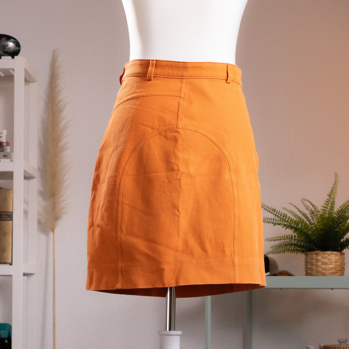 back view Archival Gucci by Tom Ford 1999 Orange Ottoman Utility Mini Skirt  sample prototype atelier– saturated carrot orange structured ottoman fabric, low rise with single gold button and belt loops, asymmetric curved seam panelling at front, dual zip pocket detail at waistband, clean A-line mini silhouette, atelier sample IT 42, product shot on dress form