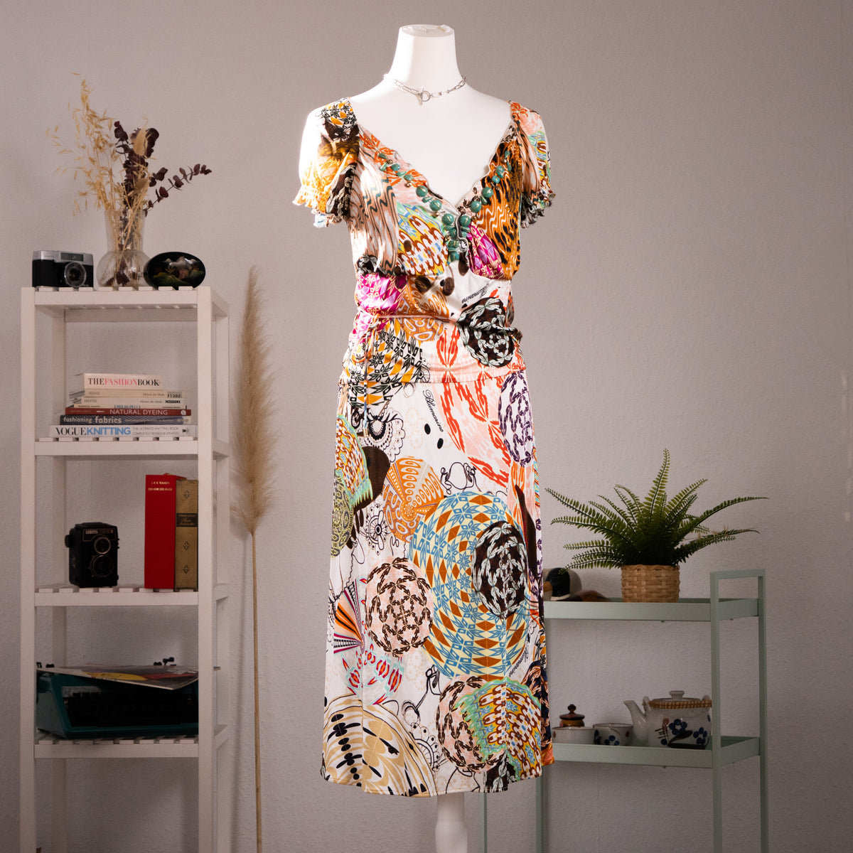 Archival Blumarine SS 2004 Jeweled Print Midi Dress by Anna Molinari – cream 100% rayon jersey with all-over trompe l'oeil jewel and ornament print in turquoise, orange, pink and brown, deep V-neckline with ruffled flutter sleeves and turquoise cabochon bead trim, wrap-style bodice, gathered waist, midi length, product shot on dress form