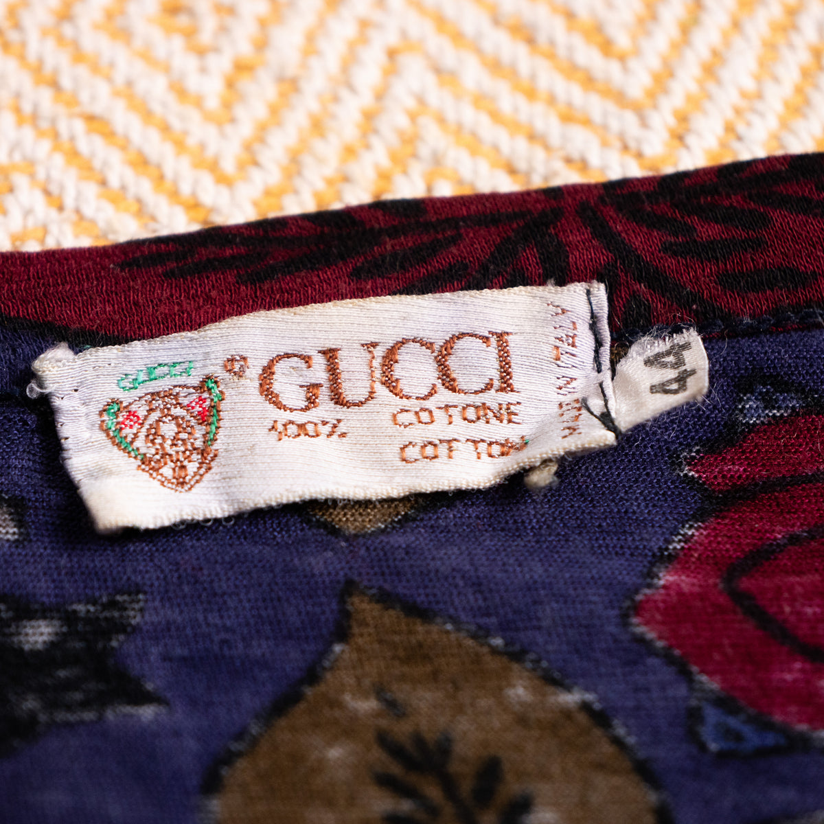 Woven vintage Gucci Crest neck label with size tag 44 from the Aldo Gucci era showcasing single-side vertical stitching.