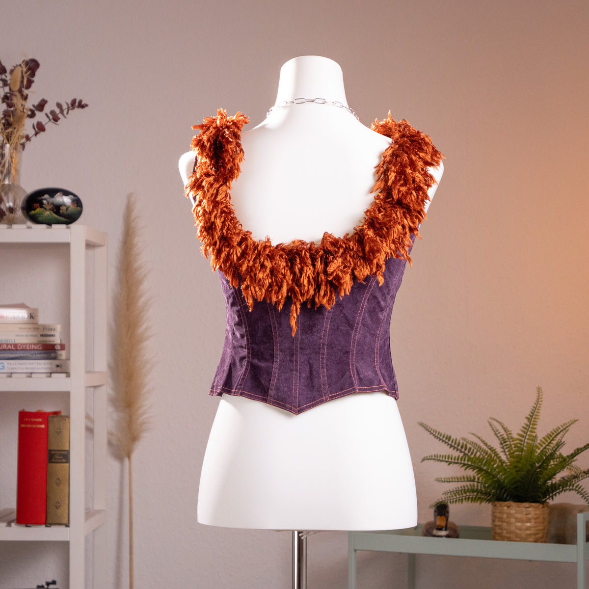 Rear view of the archival Lolita Lempicka deep purple faux suede corset top on a mannequin, showcasing the low-scoop back and copper shag fringe.