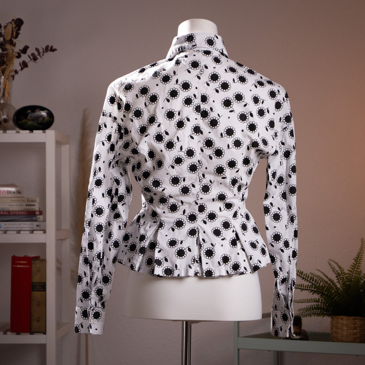 Rear view of the immaculate archival Azzedine Alaïa printed blouse showcasing the deep architectural box pleats and hourglass silhouette.