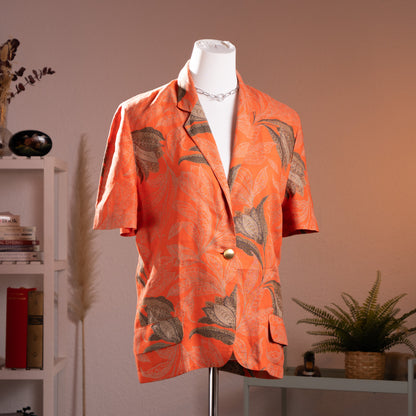 Archival Genny by Gianni Versace printed terracotta orange flax linen short-sleeve blazer from the early 1990s, front view on a gallery mannequin.
