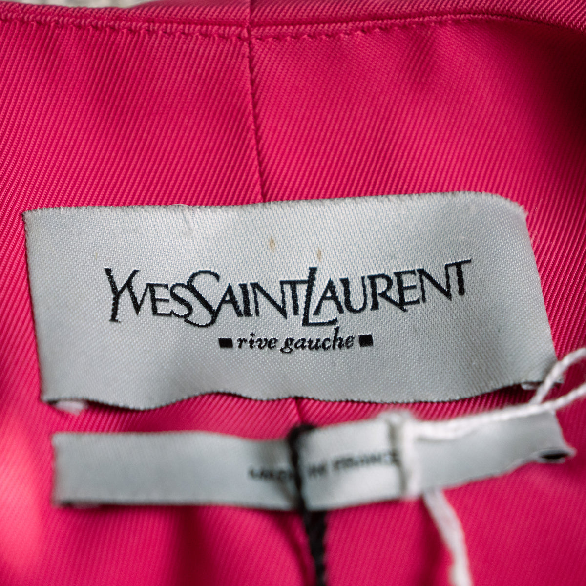 Close-up of the woven satin Yves Saint Laurent rive gauche main brand label inside the collar showing the historic typography.