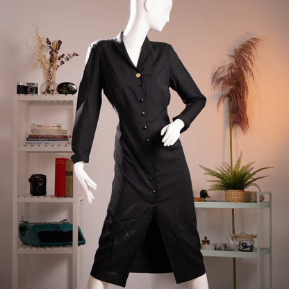 Front view of the archival Oliver by Valentino black cotton gabardine coat dress from the early 1990s on a museum mannequin.