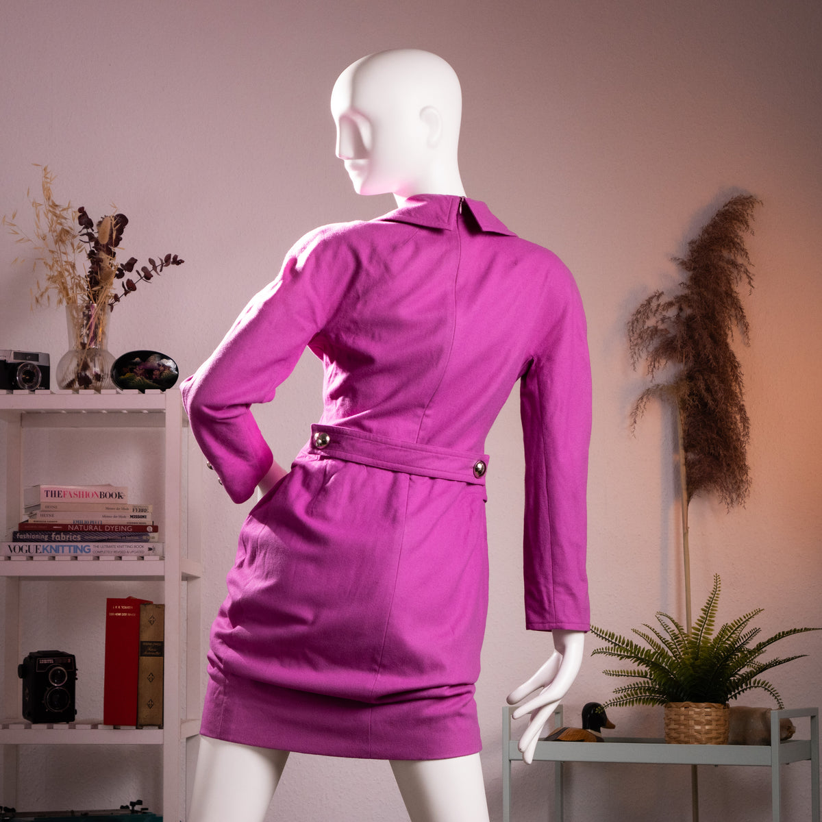Rear full-length view of the archival Courrèges late 1970s fuchsia tailored dress highlighting the structural back seam work and martingaled waist belt.