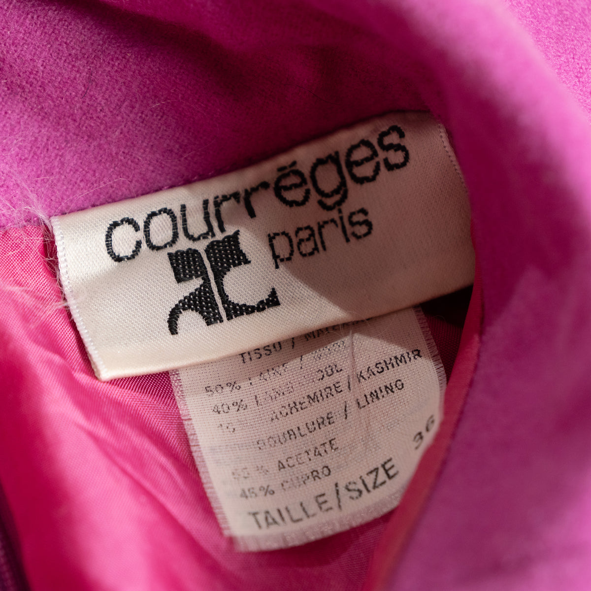 Close-up interior view of the woven white and black courrèges paris main label with the attached vintage textile composition and care tag showing Taille 36.