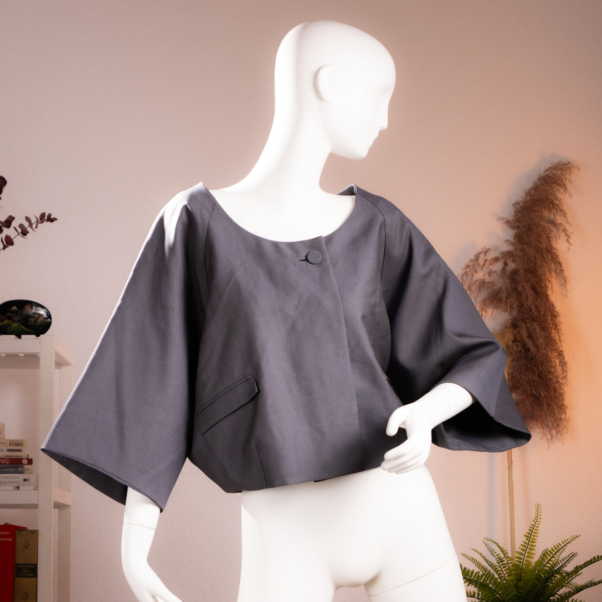 Front view of the archival Chloé cropped anthracite mohair-wool cape jacket from 2007 on a museum mannequin.