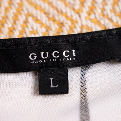 Close-up interior view of the woven black satin Gucci Made in Italy main label with the attached size L drop tag on the leather piping seam.