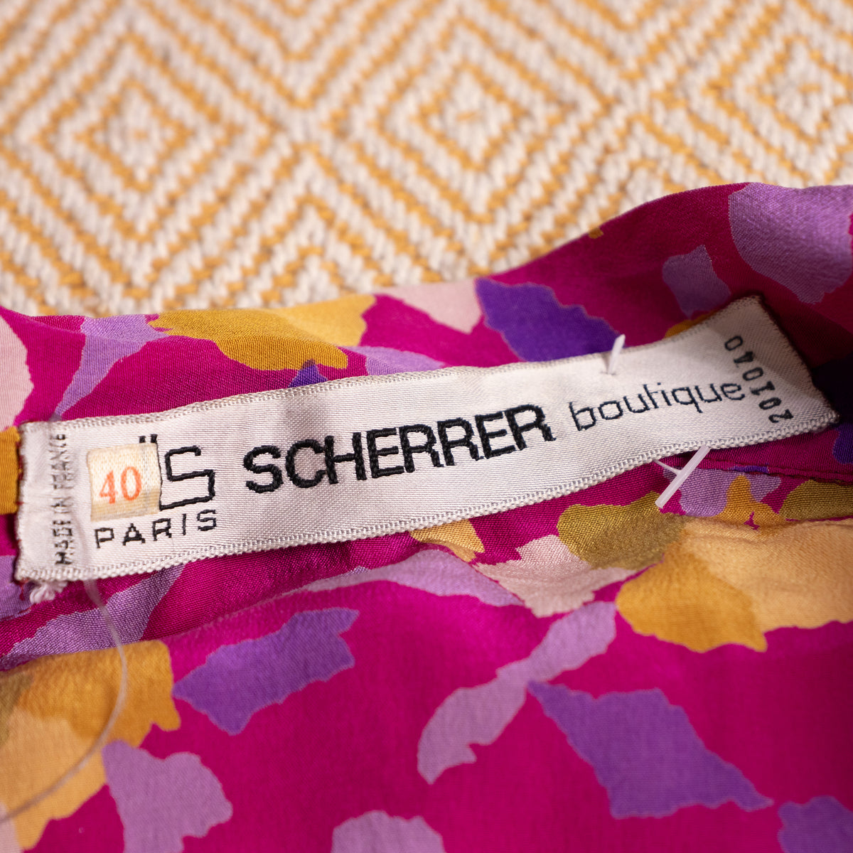 Close-up interior view of the woven white Jean-Louis Scherrer Boutique Paris neck label showing size 40 and the intact original plastic tag pin.